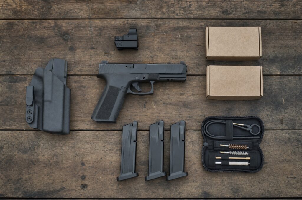 Pistol with spare magazines, holster, red dot, ammo boxes and cleaning kit, the full cost of buying your first gun